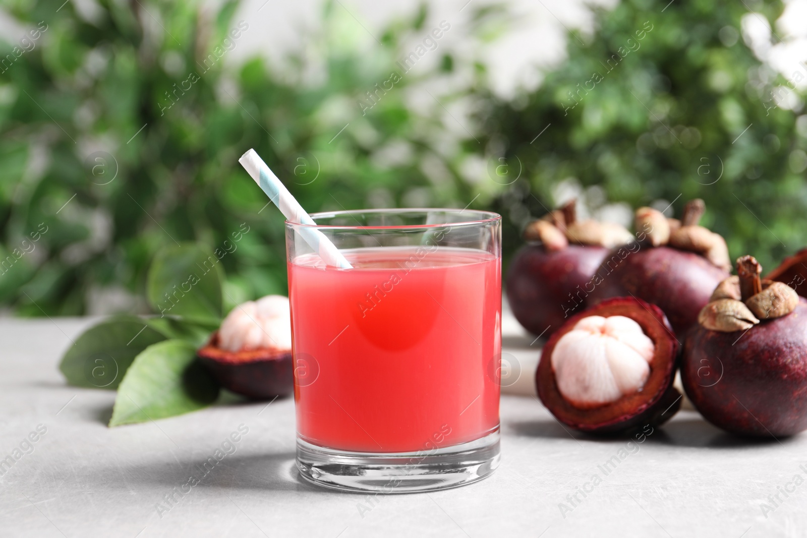 Photo of Delicious mangosteen juice in glass on light table