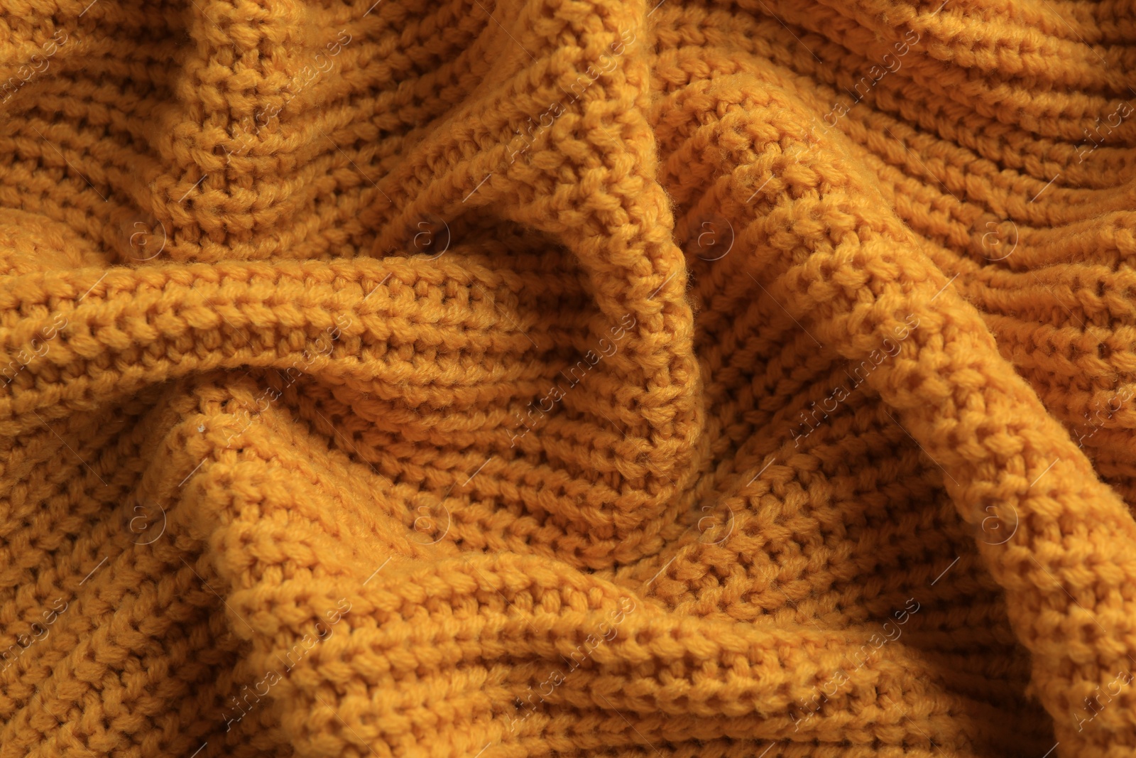 Photo of Beautiful orange knitted fabric as background, top view