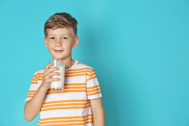 Photo of Adorable little boy with glass of milk on color background