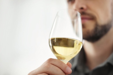 Photo of Man with glass of delicious wine indoors