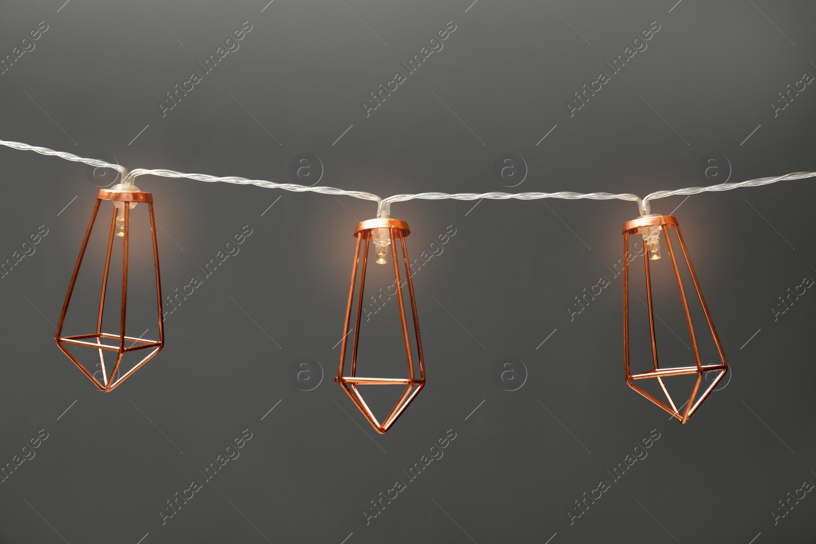 Photo of Garland of lamps with light bulbs on grey background