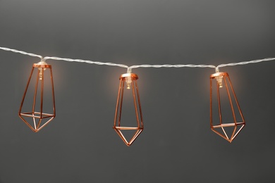 Photo of Garland of lamps with light bulbs on grey background