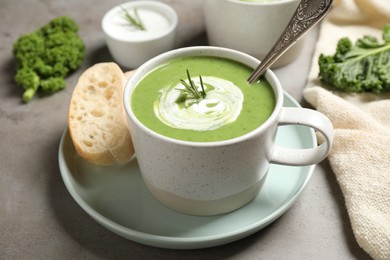 Photo of Tasty kale soup served on grey table, closeup