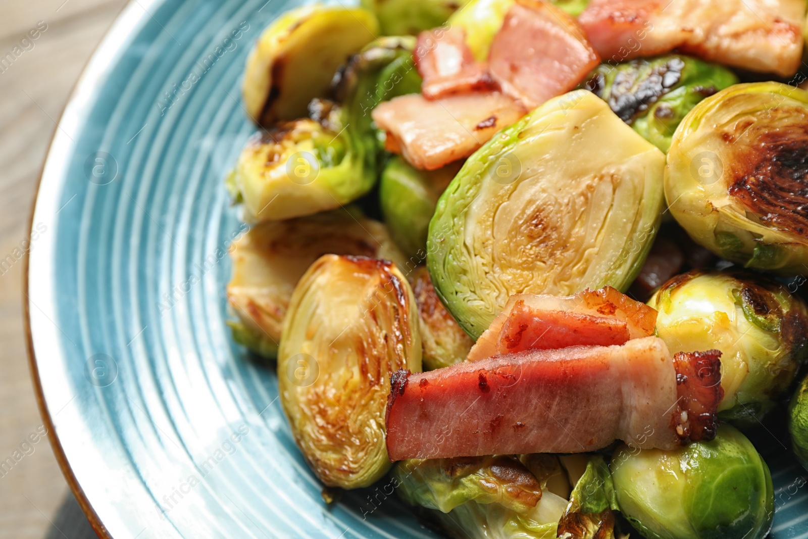 Photo of Delicious Brussels sprouts with bacon on plate, closeup