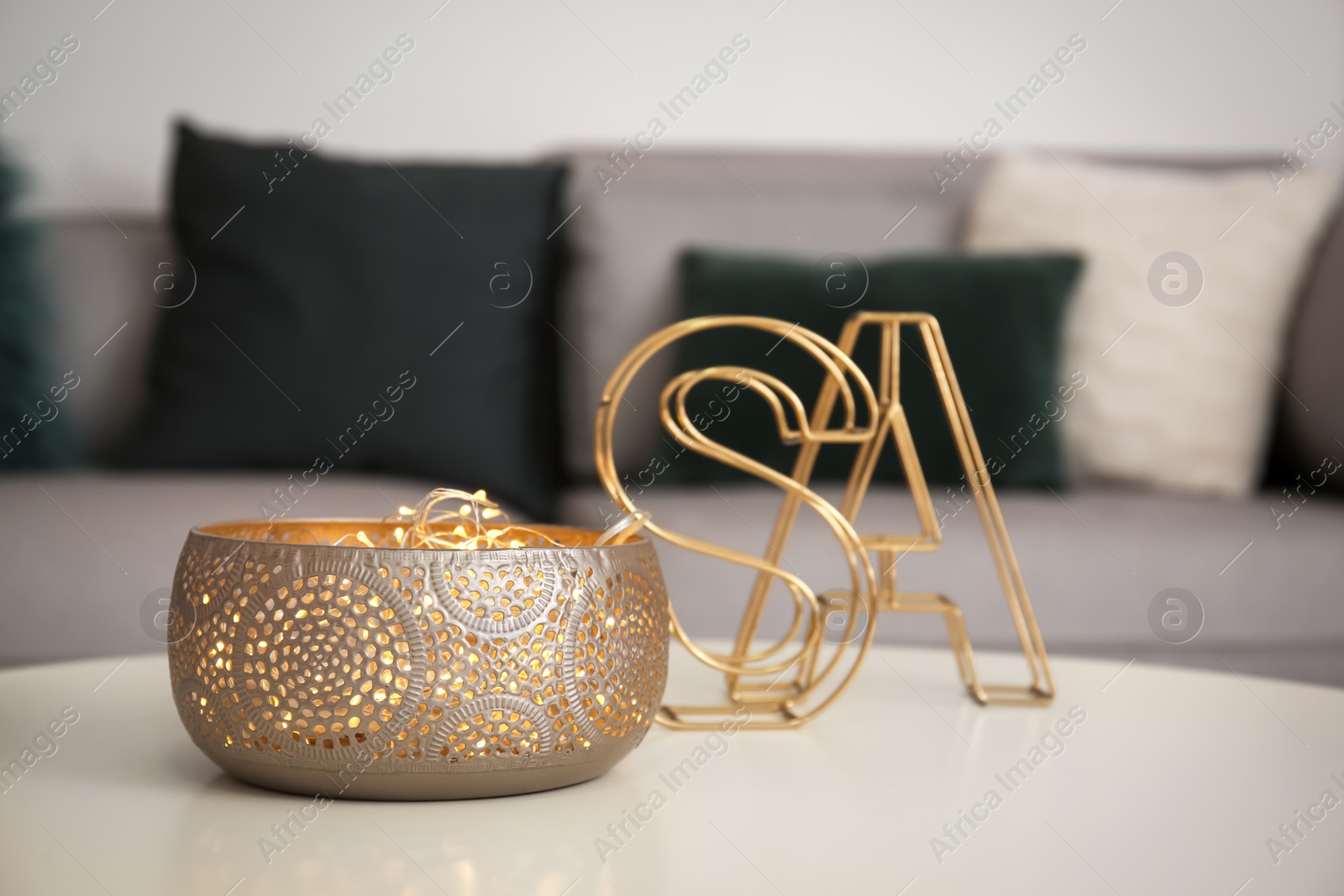 Photo of Vase with garland on table in living room. Interior design element