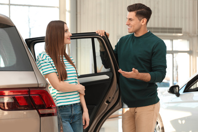 Happy couple choosing new car in dealership