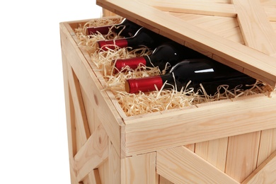 Photo of Wooden crate with bottles of wine isolated on white, closeup