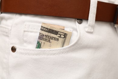 Dollar banknote in pocket of white jeans, closeup. Spending money