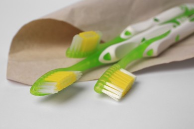 Light green toothbrushes on white background, closeup
