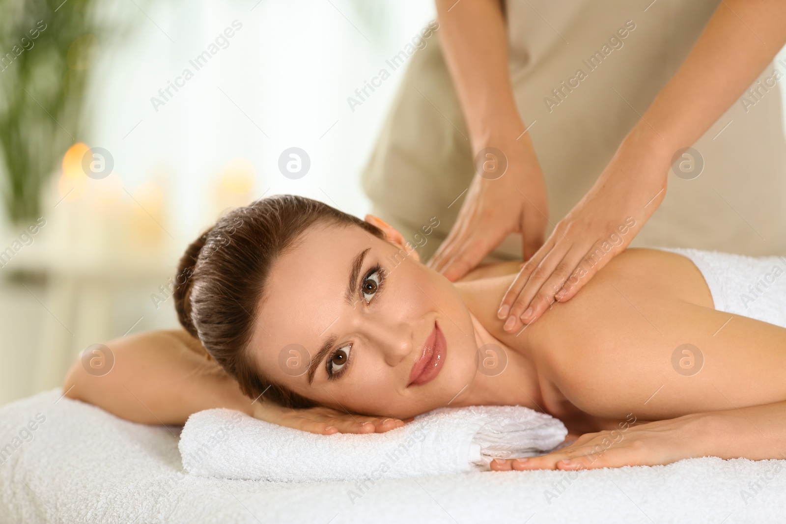 Photo of Beautiful young woman enjoying massage in spa salon