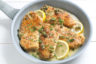 Photo of Delicious chicken piccata on white wooden table, closeup