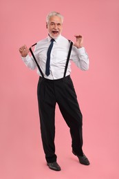 Photo of Emotional senior man dancing on pink background
