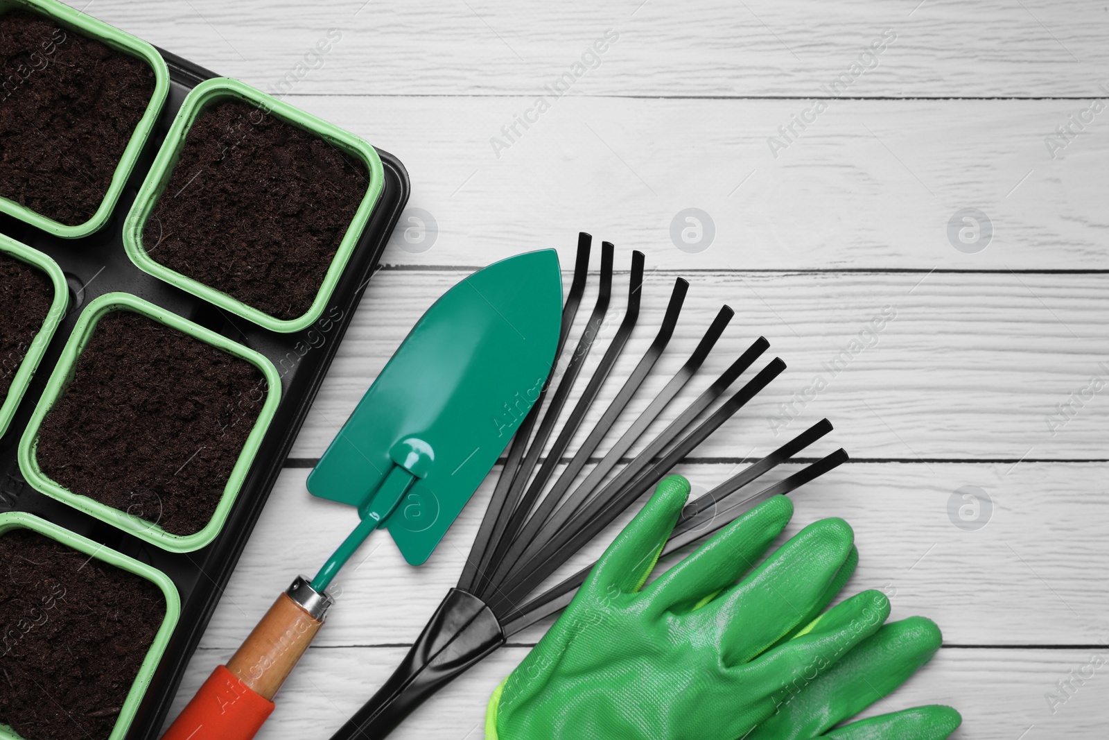 Photo of Gardening tools and pots for planting on white wooden table, flat lay. Space for text