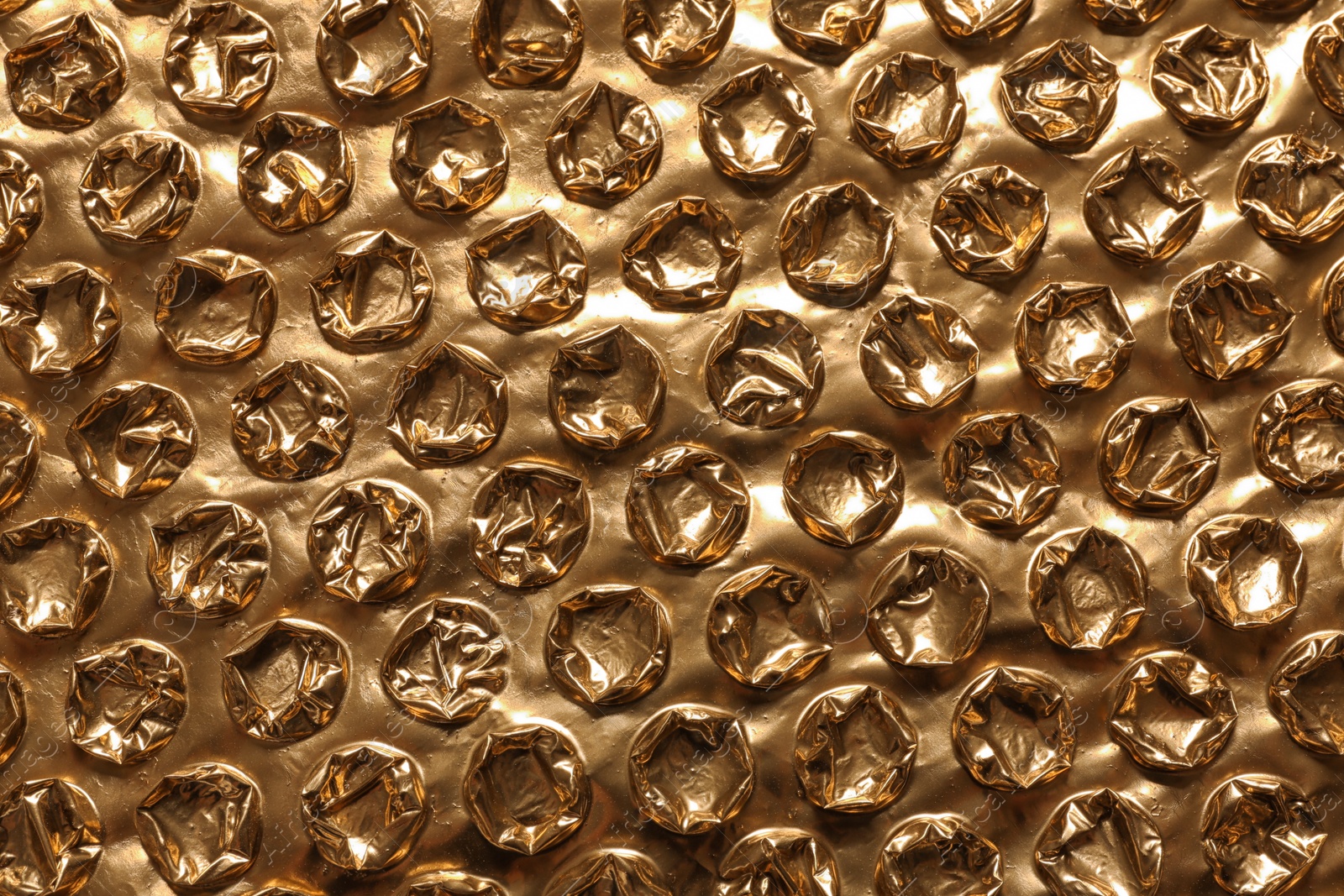 Photo of Golden bubble wrap as background, top view
