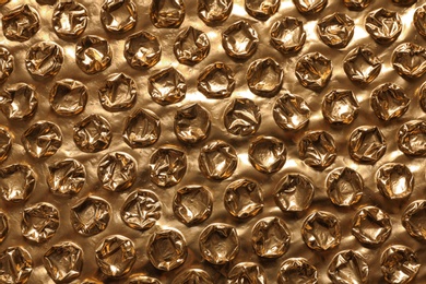 Golden bubble wrap as background, top view