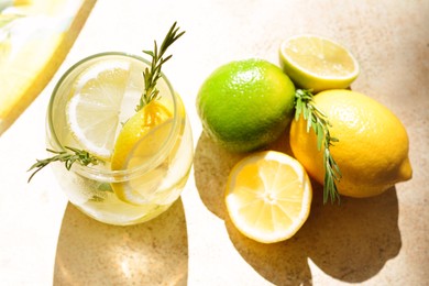 Photo of Tasty refreshing lemonade and ingredients on light table, above view. Summer drink