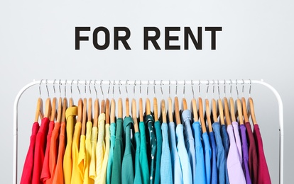 Image of Rack with bright clothes for rent on light background