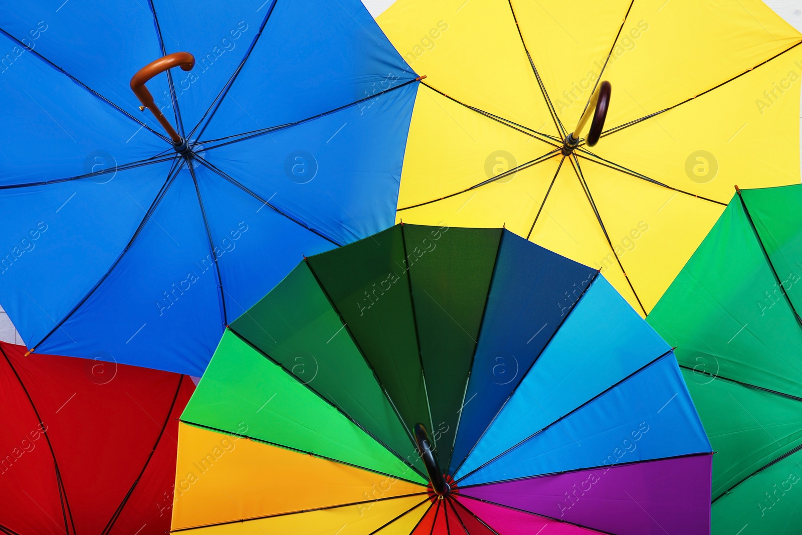 Photo of Many stylish colorful umbrellas as background, closeup