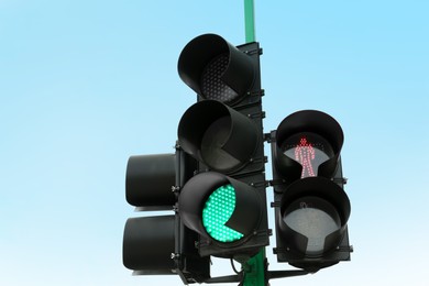 Photo of Traffic lights with red and green signals against blue sky