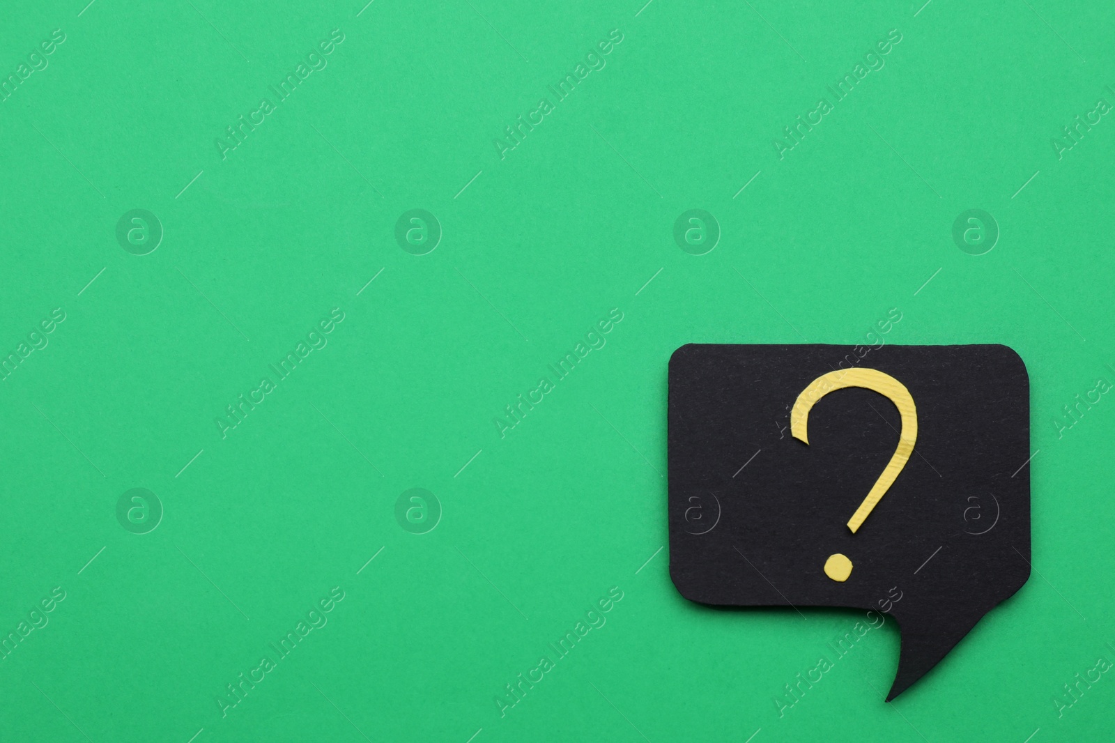 Photo of Paper speech bubble with question mark on green background, top view. Space for text