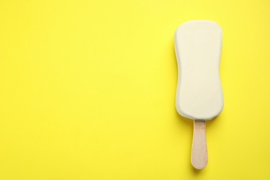 Ice cream with glaze on yellow background, top view. Space for text