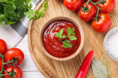 Flat lay composition with tomato sauce on white wooden table