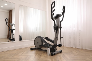 Photo of Elliptical machine cross trainer near mirror indoors