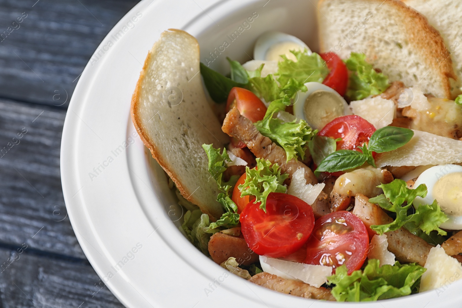 Photo of Plate with delicious fresh salad on table, closeup