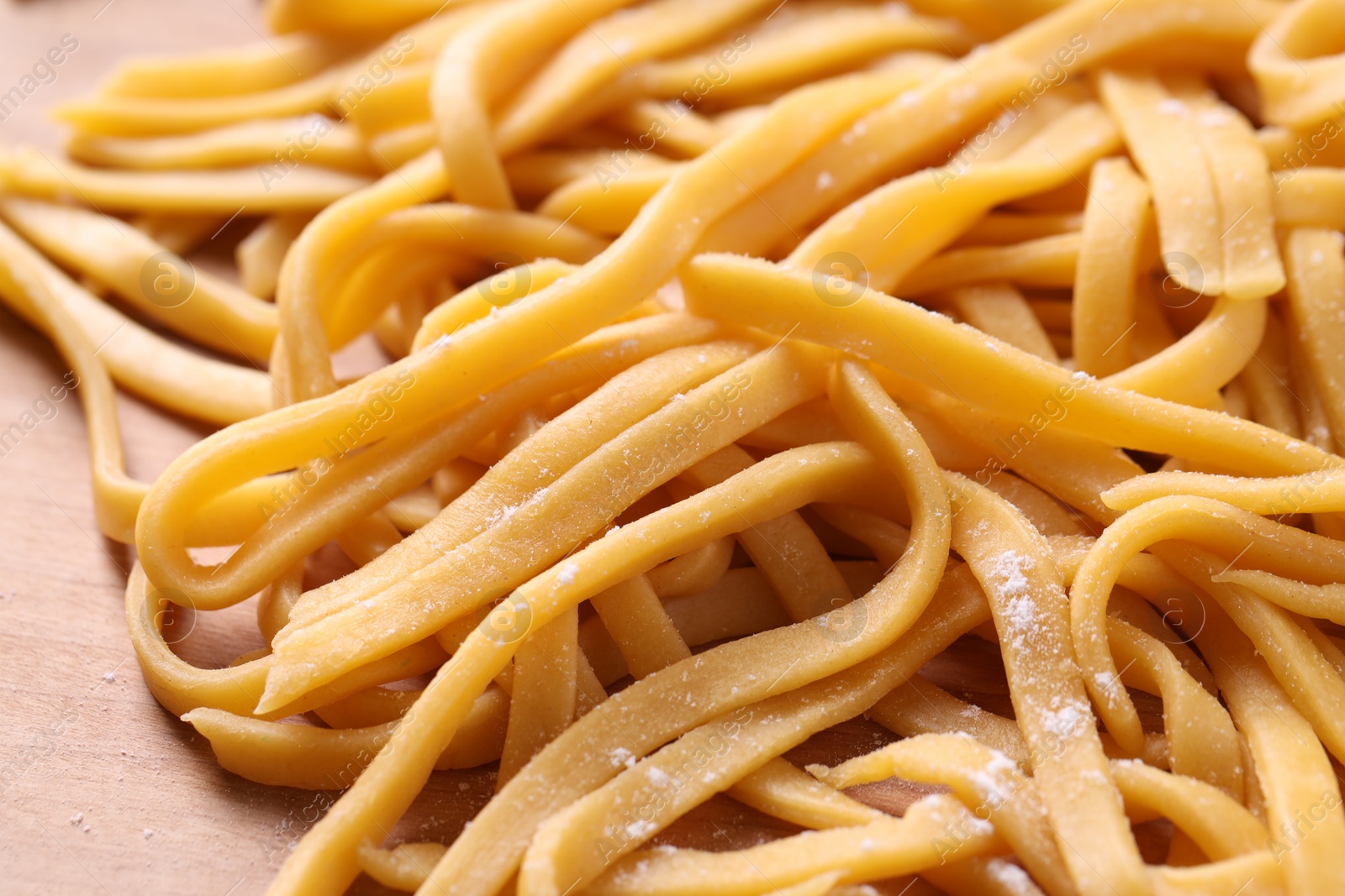 Photo of Raw homemade pasta on wooden table, closeup