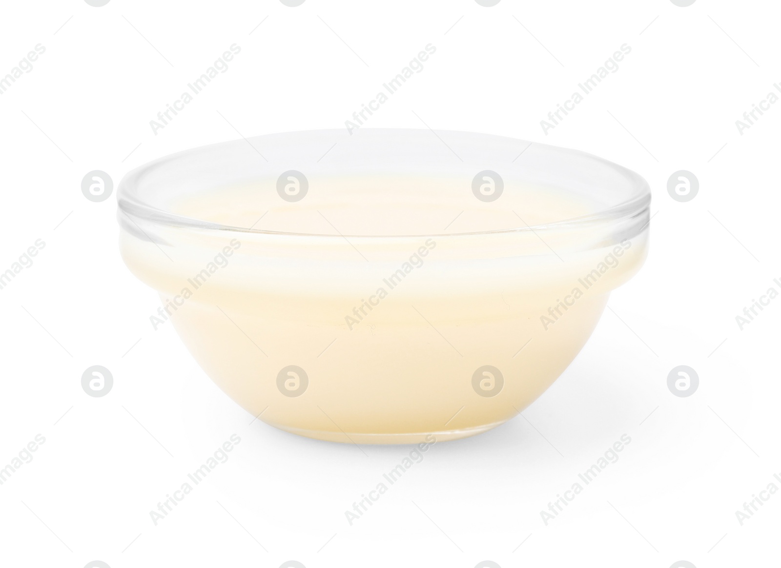 Photo of Glass bowl with condensed milk isolated on white