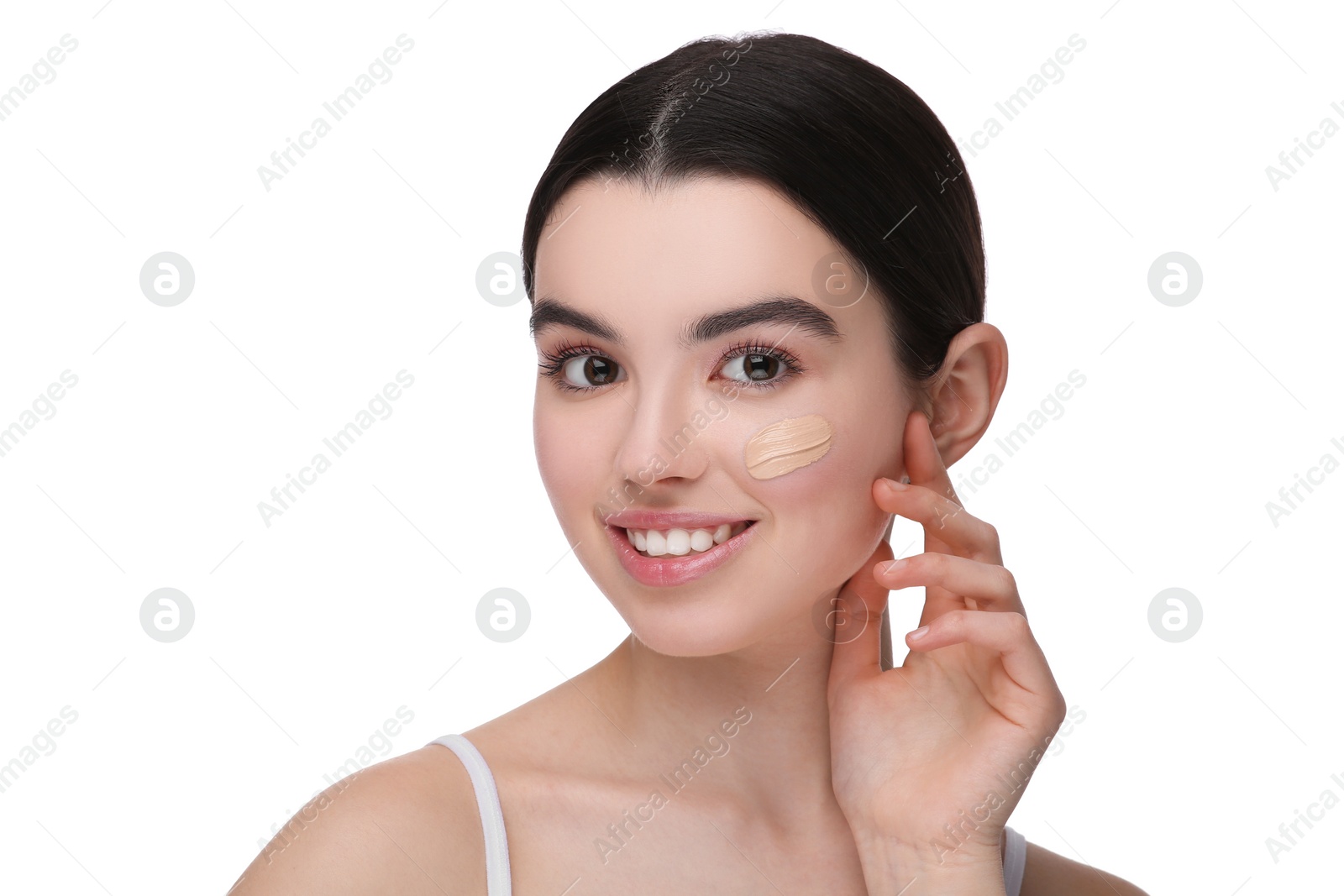 Photo of Teenage girl with swatch of foundation on face against white background