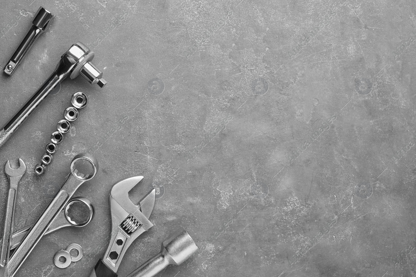 Photo of Auto mechanic's tools on grey stone table, flat lay. Space for text