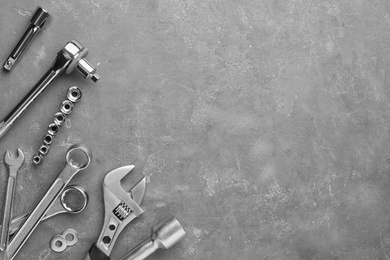 Photo of Auto mechanic's tools on grey stone table, flat lay. Space for text