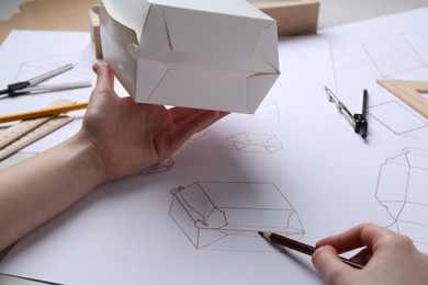 Photo of Woman creating packaging design at table, closeup