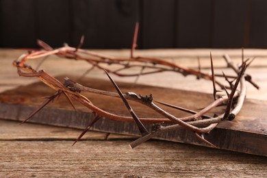 Photo of Crown of thorns on wooden table, closeup