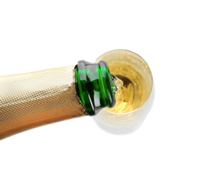 Photo of Pouring champagne from bottle into glass on white background, top view. Festive drink