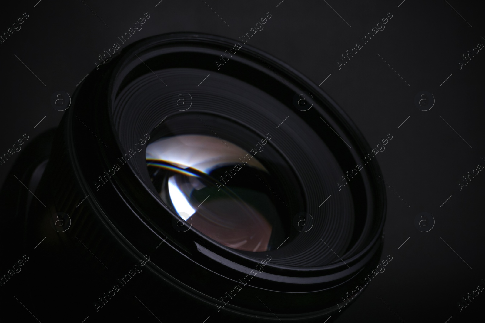 Photo of Modern camera lens on black background, closeup