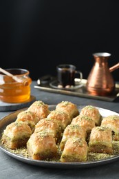 Photo of Delicious fresh baklava with chopped nuts on grey table. Eastern sweets