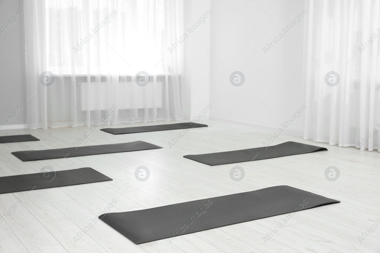 Photo of Spacious yoga studio with exercise mats. Space for text