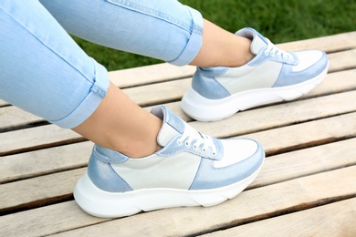 Photo of Woman wearing comfortable stylish sneakers outdoors, closeup