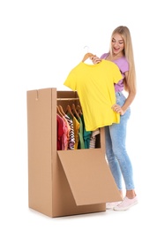 Young woman near wardrobe box on white background