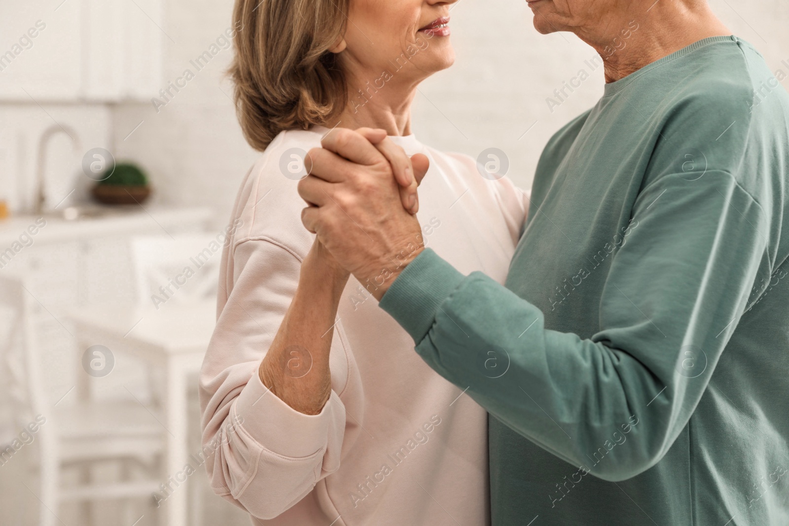 Photo of Happy senior couple dancing together at home, closeup