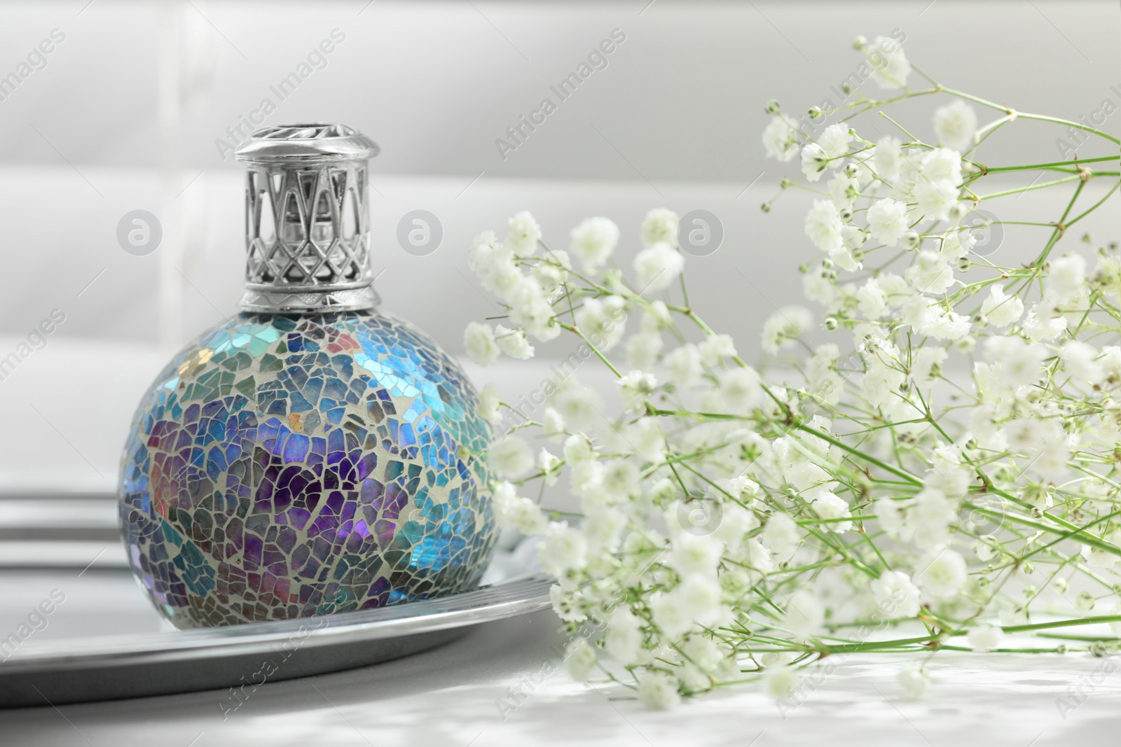 Photo of Beautiful catalytic purifying lamp and flowers on window sill. Interior element