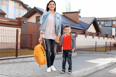 Photo of Young woman taking her little child to school