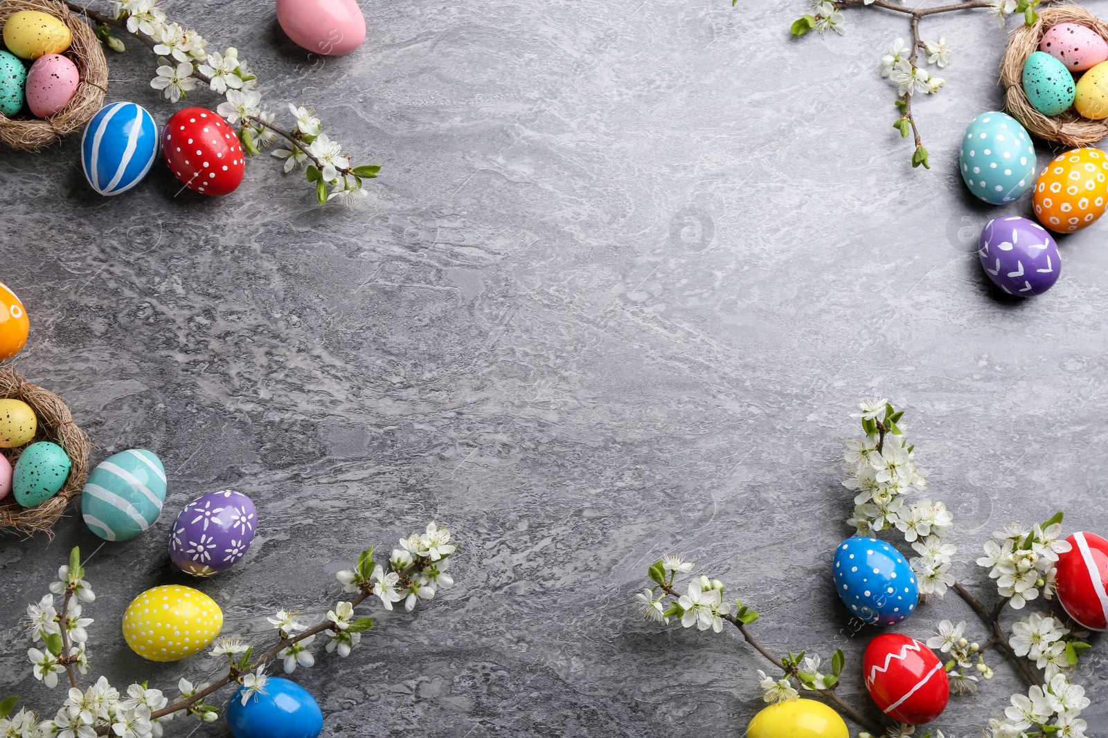 Photo of Flat lay composition with painted Easter eggs and blossoming branches on color background. Space for text