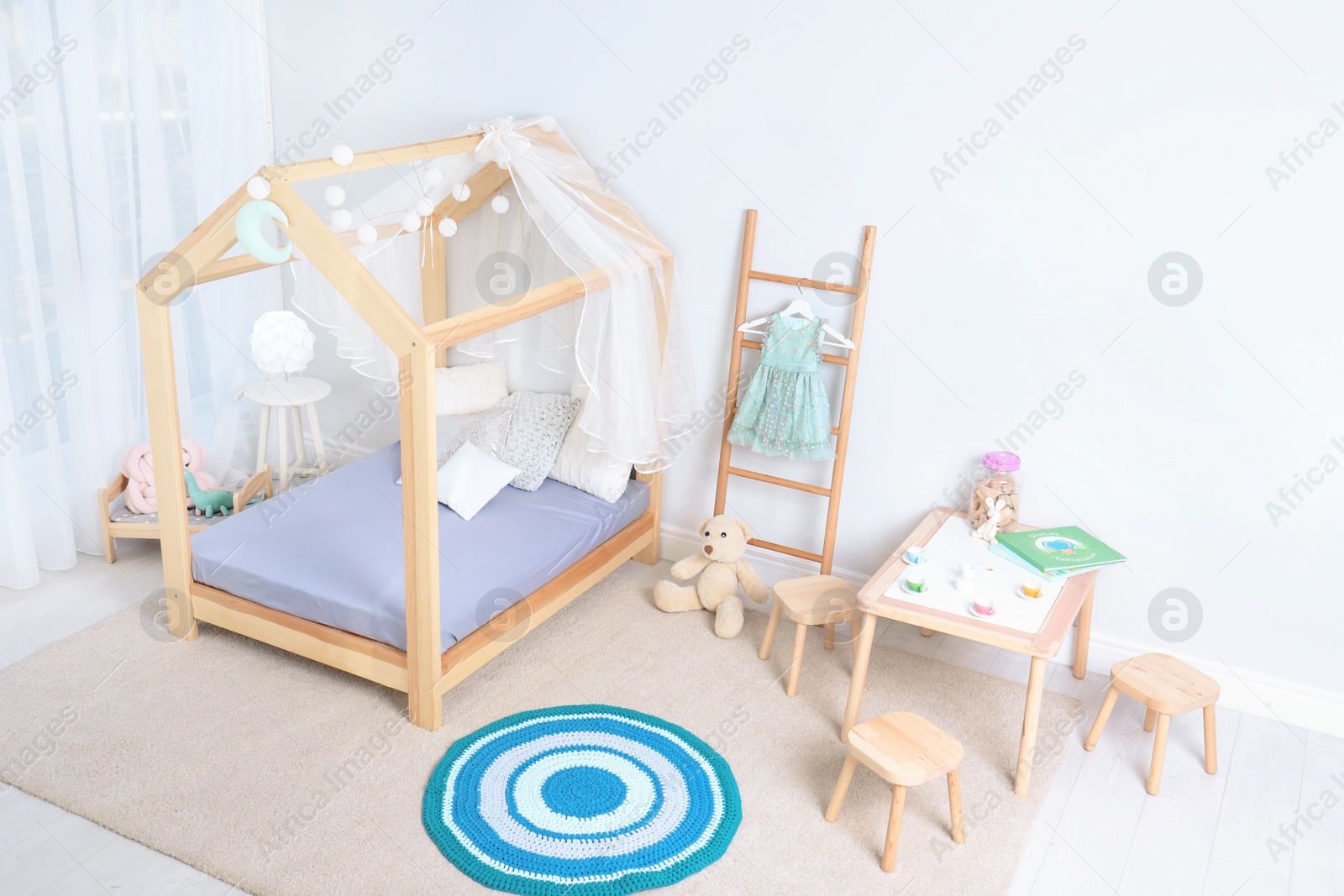 Photo of View of cozy child's room interior with cute bed