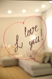 Photo of Drawn red heart with handwritten text I Love You on mirror in room. Romantic message