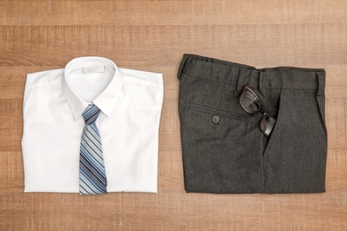 School uniform for boy on wooden background, top view