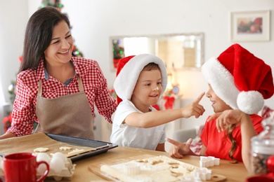Photo of Mother and children making Christmas cookies together at home