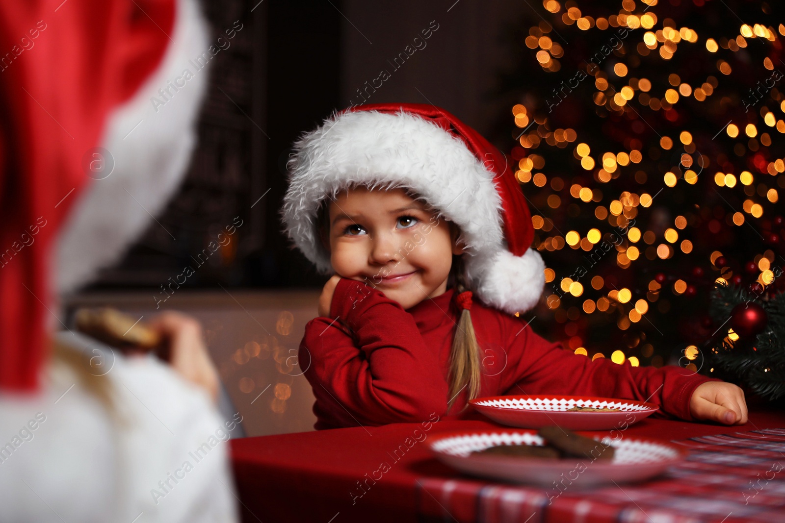 Photo of Cute little children at table in dining room. Christmas time